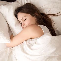 Woman soundly sleeping with sleep apnea treatment in Calimesa