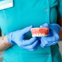 Dentist holding denture