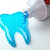 toothpaste spilling out of the tube into the shape of a tooth 