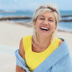 An older woman smiling on the beach