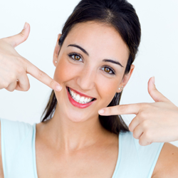 Woman pointing to bright white smile