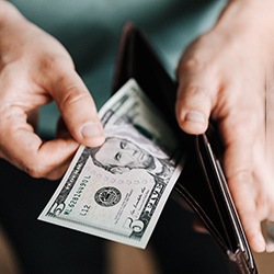 Man counting cash in wallet