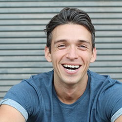 man smiling while sitting outside 