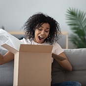 woman excitedly opening a package 