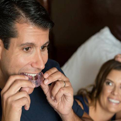 Man placing oral appliance before bed