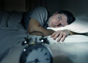 A man lying in bed awake.