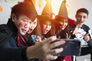 adults dressed up as witches and vampires and taking a picture together