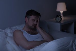 Man in bed unable to sleep