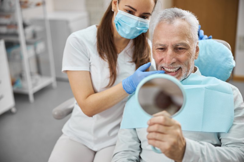 An older man happy with his dental implant success