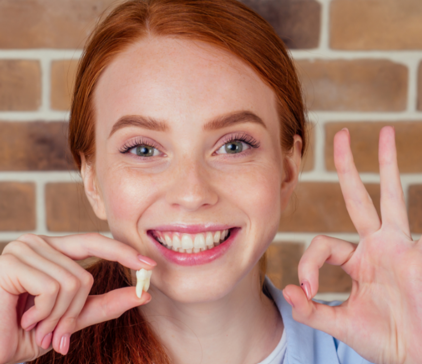 Smiling woman holding a tooth